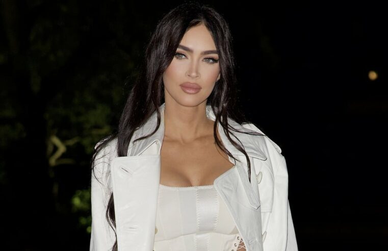 Megan Fox usa espartilho branco, calça flare e trench coat