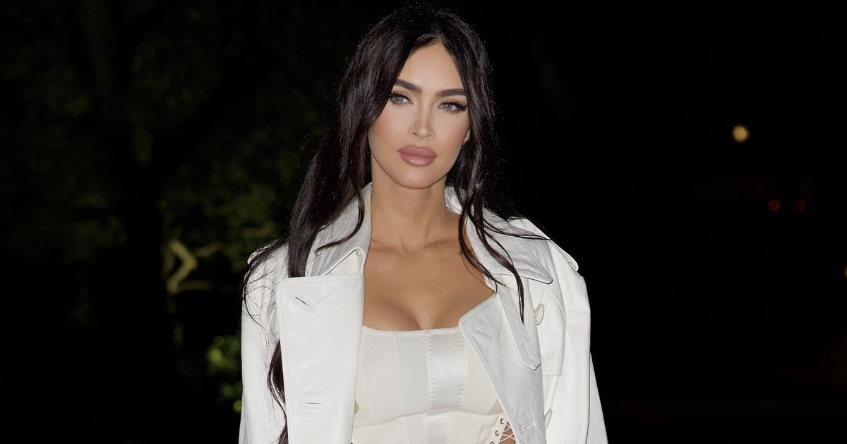 Megan Fox usa espartilho branco, calça flare e trench coat